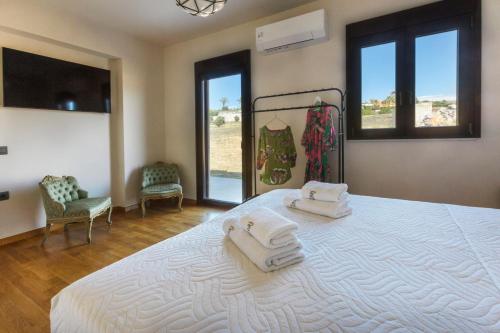 Un dormitorio con una cama grande con toallas. en Villa Haria, en Káto Váthia