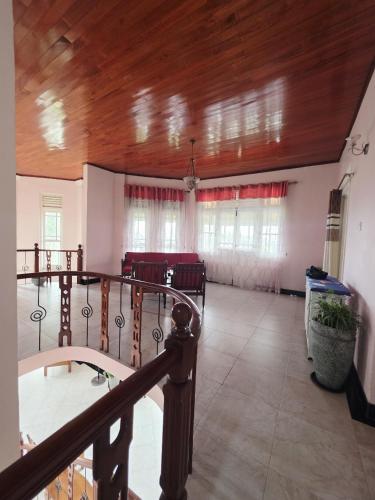 a large room with a wooden ceiling and windows at Peak Lodge in Kandy