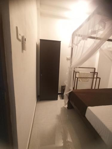 een slaapkamer met een bed en een zwarte deur bij Sandeepa Villa in Galle