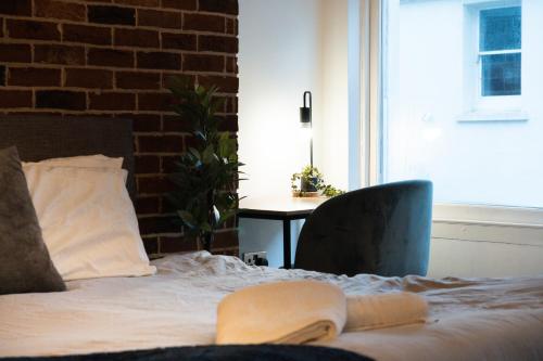 a bedroom with a bed with a chair and a table at Chic Brighton Studio in Brighton & Hove