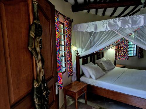 een slaapkamer met een hemelbed bij Petasha Bustani Villas Diani with pool and parking in Galu