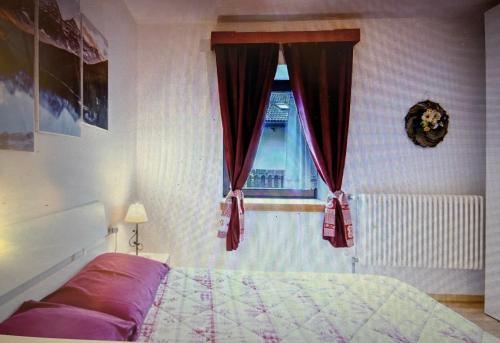 a bedroom with a bed and a window at Appartamento GIRASOLE in Trodena