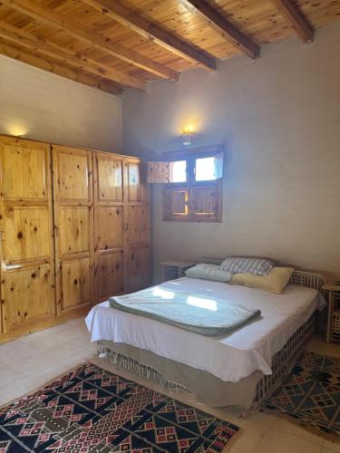 a bedroom with a bed with wooden cabinets and a window at Facilie Home Siwa in Siwa