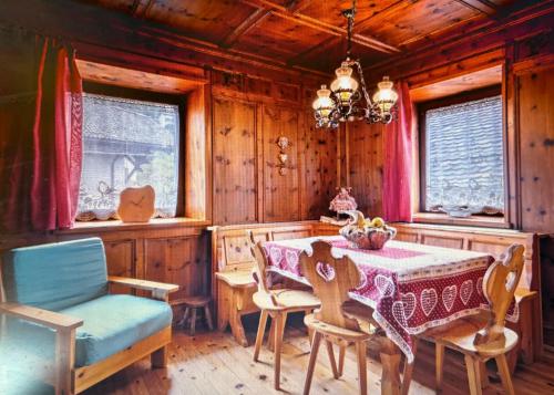 a dining room with a table and chairs and a chandelier at Appartamento GIRASOLE in Trodena