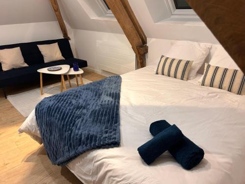 Le CatelierにあるMaison Le Catelierのベッドルーム1室(白いベッド1台、青いタオル付)