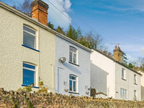 een wit huis met blauwe ramen en een hek bij Valley View in Malvern Wells