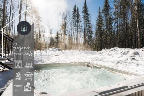 a hot tub covered in snow with trees in the background at Nature & lake access Tremblant in Saint-Rémi-dʼAmherst