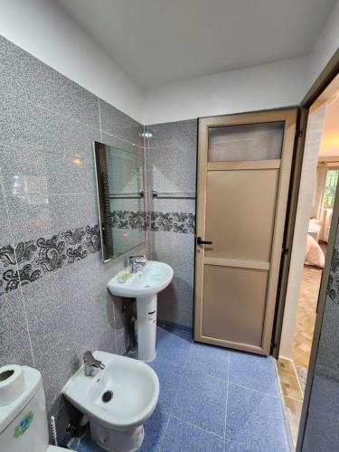 een badkamer met een wastafel, een toilet en een spiegel bij Residence Imlil Ouarzazate in Ouarzazate