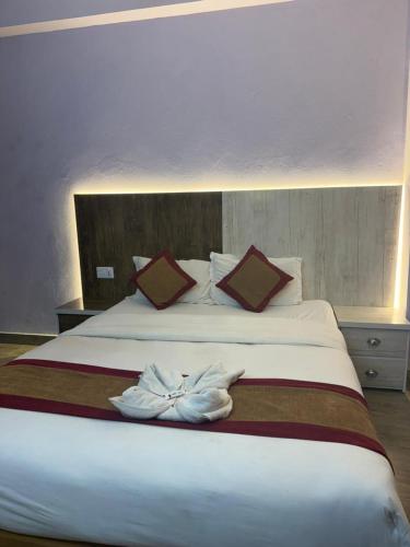 a bedroom with a large white bed with two pillows at Hotel sunrise heaven in Pokhara