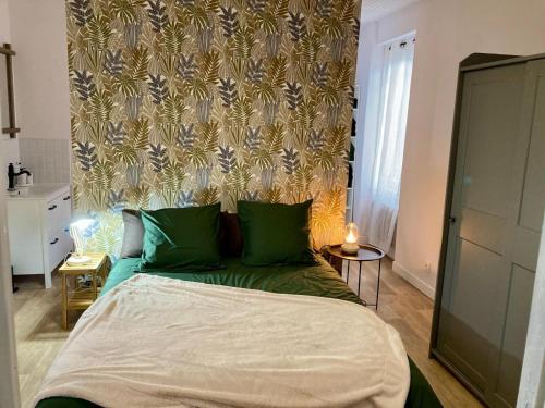 un letto con cuscini verdi in una camera da letto di La Longère a Vierzon