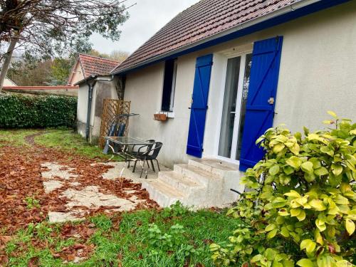 una casa con una porta blu e un tavolo di La Longère a Vierzon