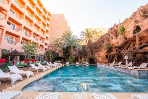 マラケシュにあるインペリアル ホリディ オテル ＆ スパのラウンジチェアとリゾートを備えたプール