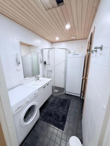 a bathroom with a washing machine and a shower at Premium Chalet huoneisto kylpylän vieressä in Vierumäki