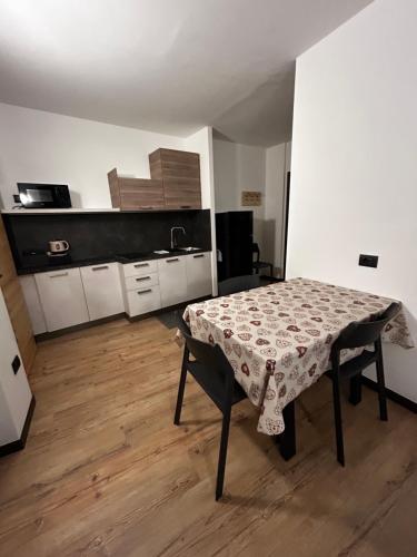 eine kleine Küche mit einem Tisch in einem Zimmer in der Unterkunft Tilde in Tesero
