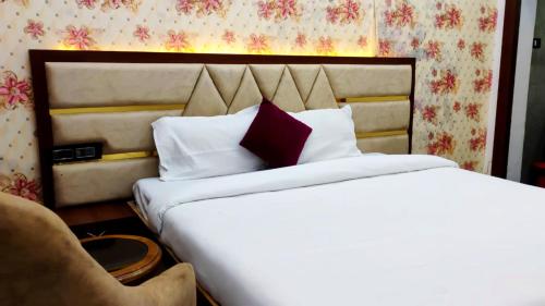 ein Schlafzimmer mit einem großen Bett und einem Stuhl in der Unterkunft Hotel Premimum Kashi Satya Luxury-Parking Facility #Near KASHI VISHWANATH TEMPLE# in Varanasi