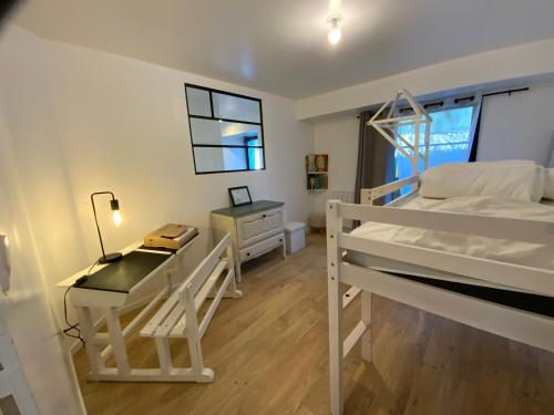 1 dormitorio con escritorio y litera en Appartement avec son jardin face au port d'Audierne, en Plouhinec