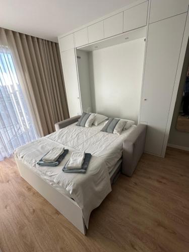 a bedroom with a large bed with two towels on it at New Douro Tower 206 with shared pool in Vila Nova de Gaia