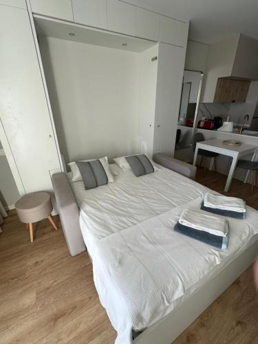 a bedroom with a large white bed with towels on it at New Douro Tower 206 with shared pool and parking in Vila Nova de Gaia