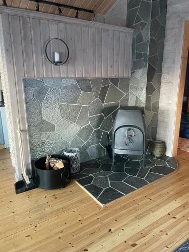 a kitchen with a stone wall with a stove at Sørstraumen View in Nordstraumen