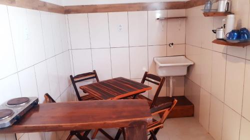 eine Küche mit Tisch und Stühlen und einer Spüle in der Unterkunft Apartamentos Nova Caraiva in Caraíva