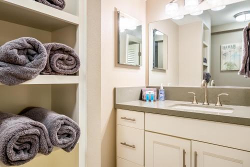 een badkamer met een wastafel en een spiegel bij Kihei Akahi C210 in Wailea