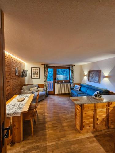 een woonkamer met een blauwe bank en een tafel bij Il rifugio del Bianco in Courmayeur