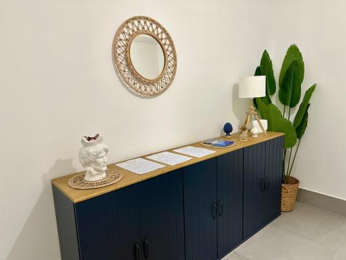 a blue cabinet with a mirror on the wall at Argyros Rooms in Giardini Naxos