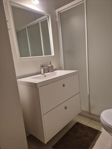 a white bathroom with a sink and a mirror at A casa do cervo in Vila Nova de Cerveira