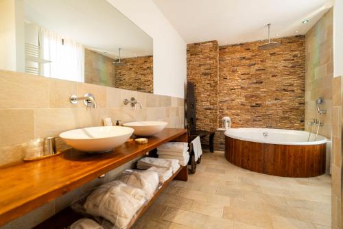 PianoB - Breakfast Hotel & Bar في سينِغاليا: حمام مع مغسلتين وحوض استحمام