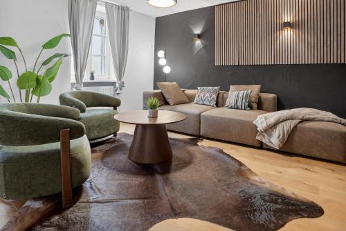 a living room with a couch and two chairs and a table at 3 Queen Beds Waterfall Garage Terrace Center in Saarburg