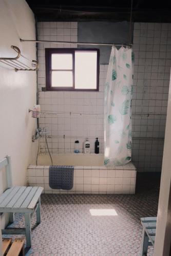 a bathroom with a shower and a bench in it at A Touch of Zen in Kaohsiung