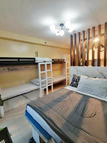 a bedroom with a large bed and a desk at Meraki Space Mactan Cebu in Lo-oc