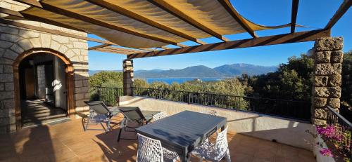 Maison de Charme Vue Exceptionnelle Mer & Montagne في كامبومورو: فناء مع طاولة وكراسي على شرفة