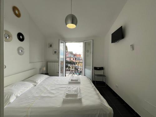 ヴェルナッツァにあるOld Town Roomsのバルコニー付きの客室の白いベッド1台分です。