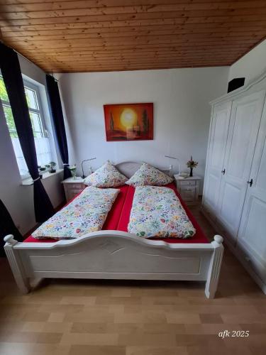 a bedroom with a large bed with red sheets at Casa-Flores, um"Schwarzes Gold" zu erkunden in Bad Fallingbostel