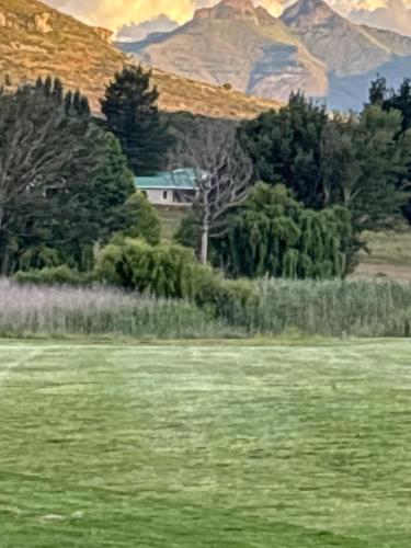 un tableau représentant un champ avec des arbres et une maison dans l'établissement 127 Clarens Golf Villa, à Clarens