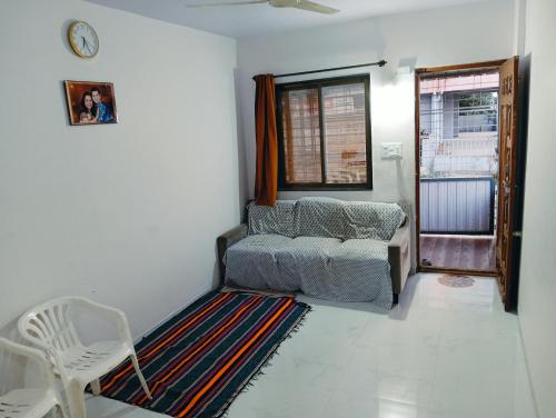 a living room with a couch and a chair and a window at Sukhada Nivas Bunglow in Trimbak