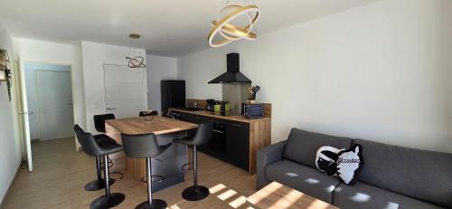 a living room with a couch and a table at Joli T2 cozy, proche plages, Terra Doru B02 in Propriano