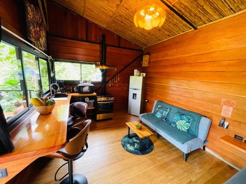 a living room with a couch and a kitchen at Cabaña Río San Carlos Ecolodge in Boca Tapada