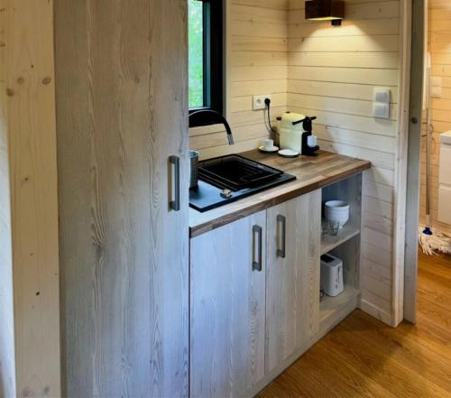 een keuken in een tiny house met een aanrecht bij Cabane 3 étoiles - ccbechc in Neuilly-sur-Marne