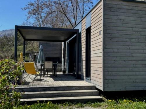 a building with a patio with a table and chairs at ZEcamping 3 étoiles pet friendly restaurant avec une vue panoramique in Gap