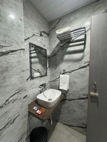 a bathroom with a sink and a stone wall at OM Hotel in Sirohi