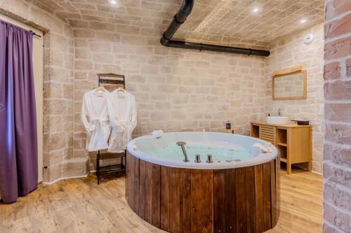 Una bañera en una habitación con una pared de ladrillos. en La voûte des Baous, en Vence