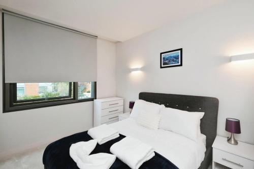 a white bedroom with a bed and a window at Modern 1 Bed Apt Bracknell- with parking in Bracknell