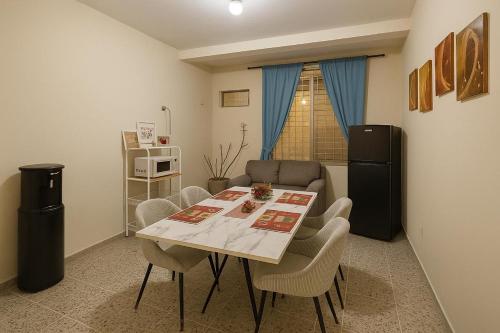 Una sala de estar con una mesa y sillas y un sofá. en Go Bed & Breakfast, en San Pedro Sula