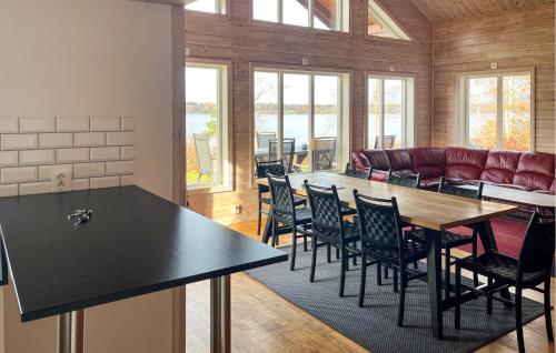 Amazing Home In Bolmsö With Sauna في Bolmsö: غرفة طعام بها طاولة وكراسي