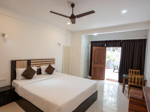 Un dormitorio con una cama grande con ventilador de techo. en Puthooram Seaview Cliff Resort, en Varkala