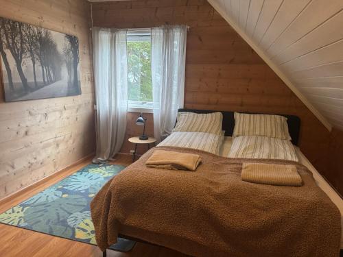 a bedroom with a large bed with a window at Superkoselig familiehus med lekerom - Barnevennlig in Vossevangen