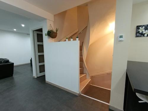 a hallway with stairs and a white wall at Glauque Room Horror and cinema themed studio in Béziers