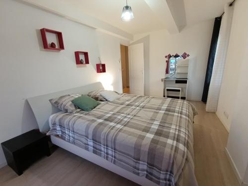 una camera da letto con un letto con una coperta scozzese di Angleterre 48 a Béziers